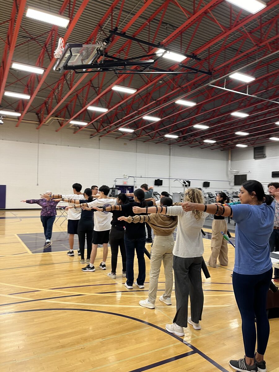 A large group of club members practicing their form together, without bows